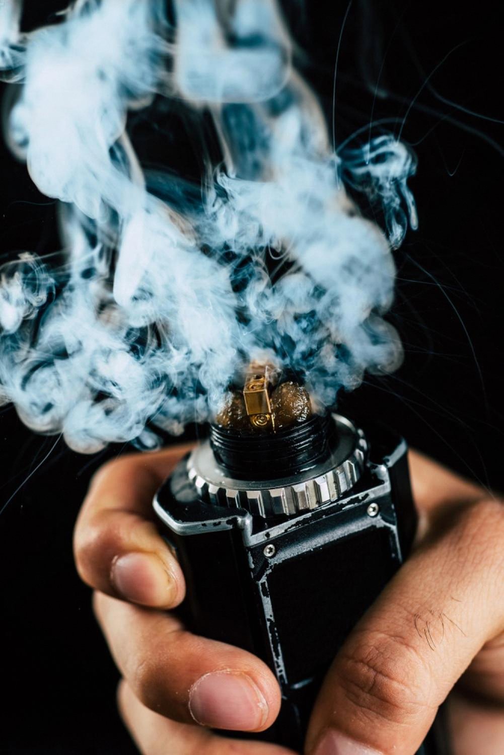 Close-up of a glowing vape coil heating e-liquid and generating dense vapour